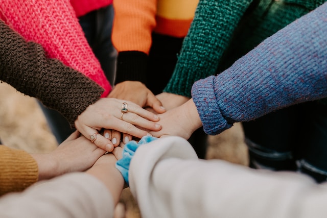 hands of diverse workers together in a pile