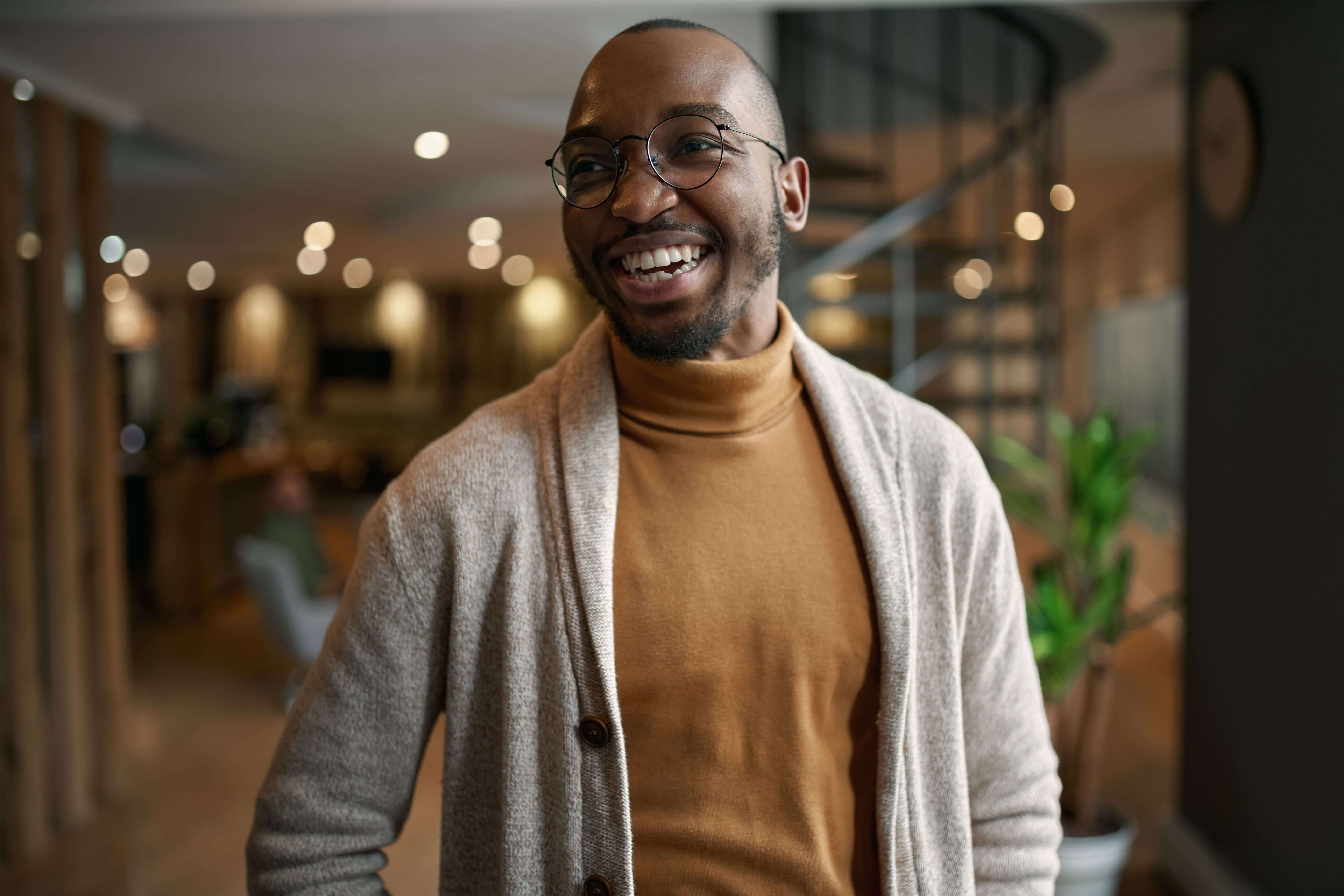 Colleagues in a meeting room smiling, demonstrating a positive and cooperative atmosphere in the workplace.